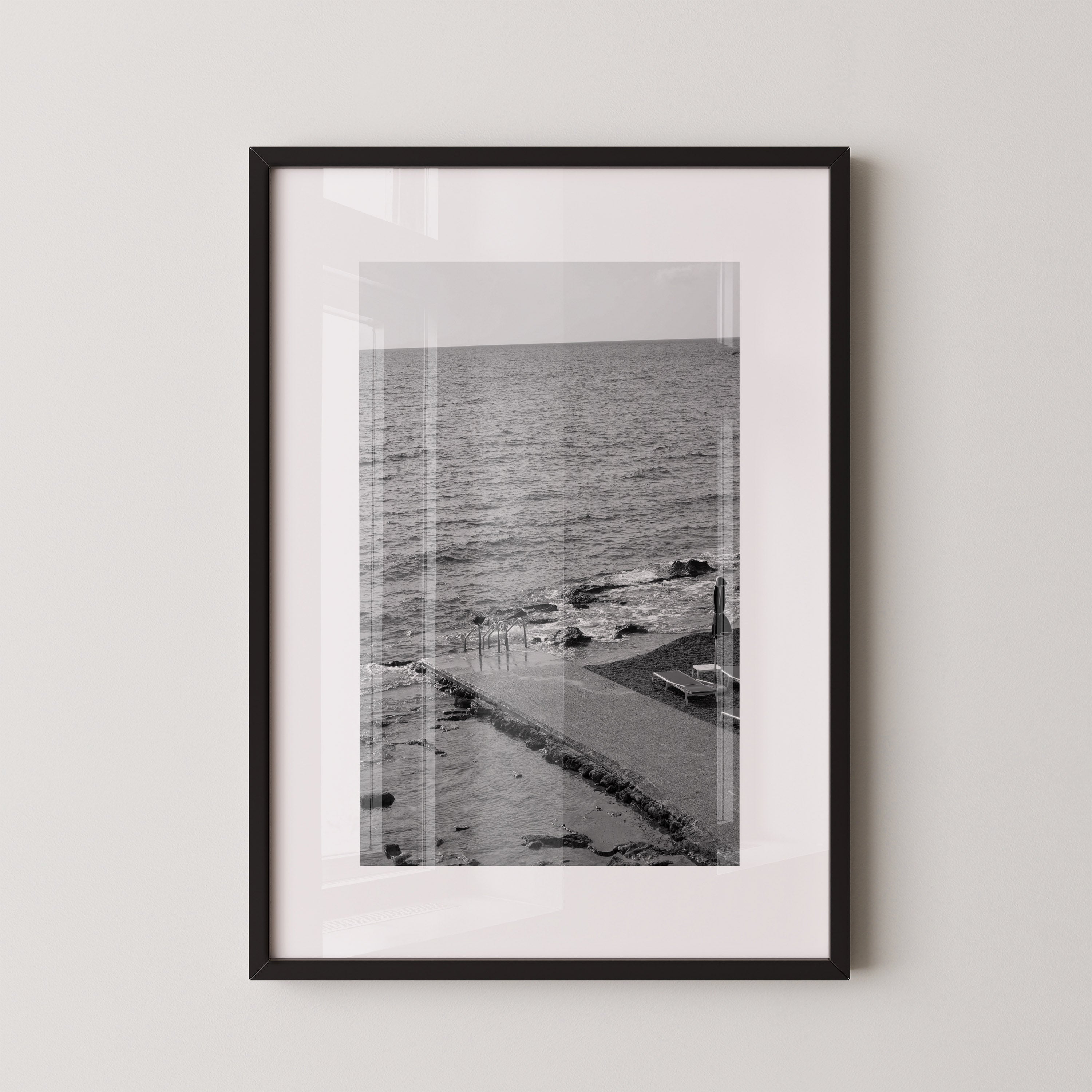 The Quiet Pier by Danielle Berlot – צילום אמנותי בשחור־לבן של מזח שקט היוצא אל הים ברודוס, במסגרת עץ אלון.