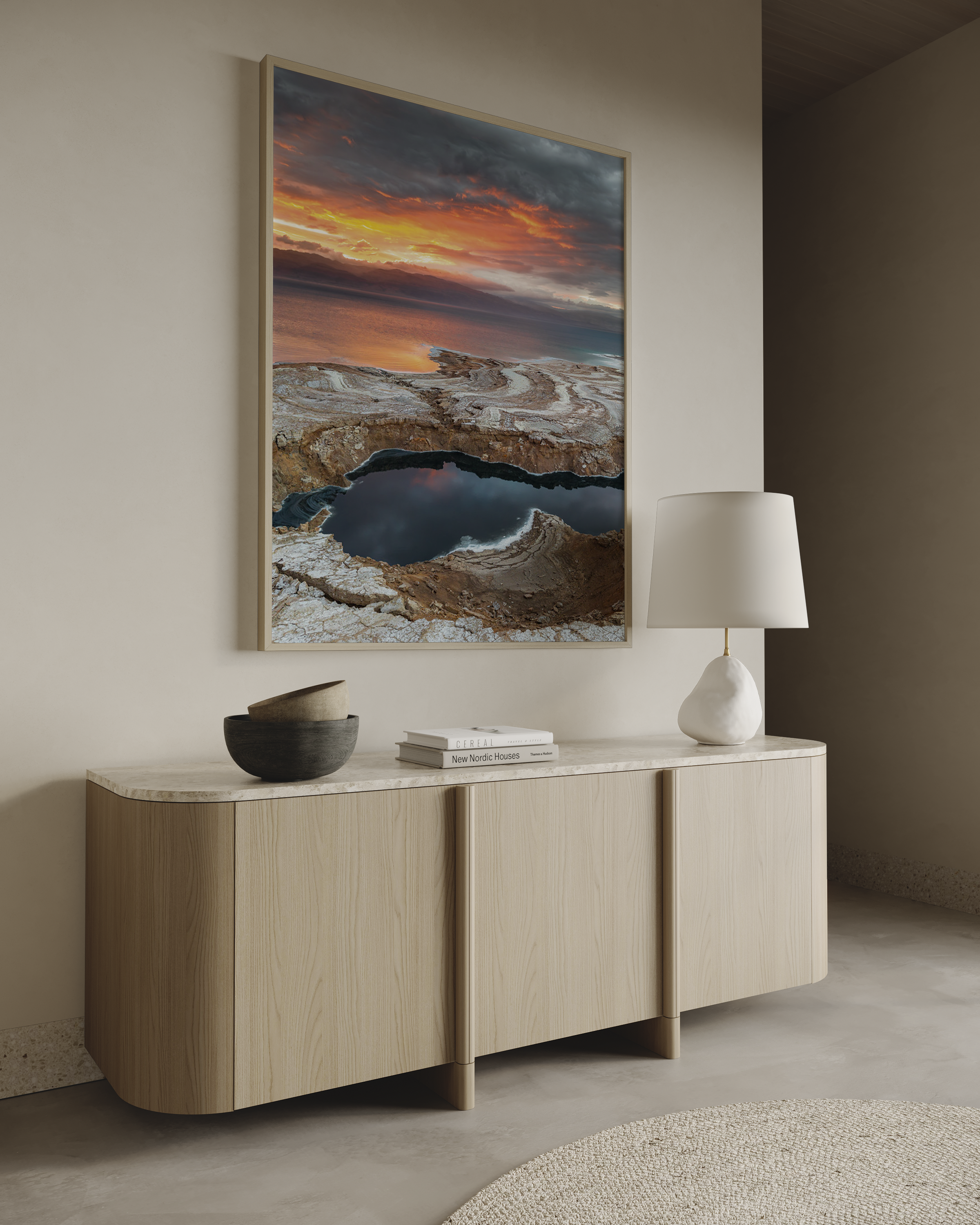 יצירה ממוסגרת של גלעד טופז בצילום זריחה בעין גדי, שמיים כתומים דרמטיים משתקפים בבריכות מים ומלח לאורך חוף ים המלח