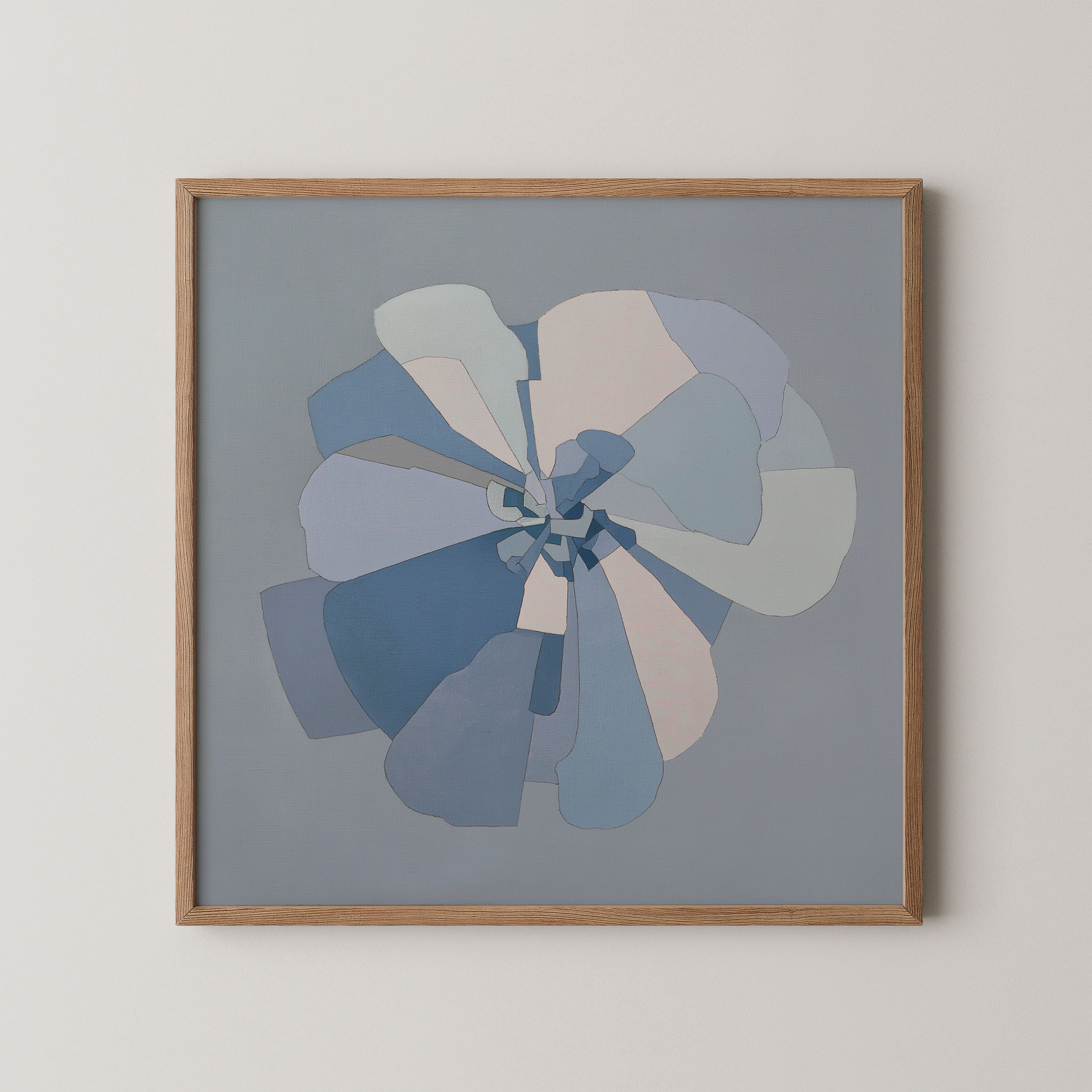 יצירת אמנות מופשטת בגווני כחול, שמנת ואפור בהיר המדמה פרח פתוח עם שכבות חופפות, ממוסגרת במסגרת עץ כהה על קיר בהיר
