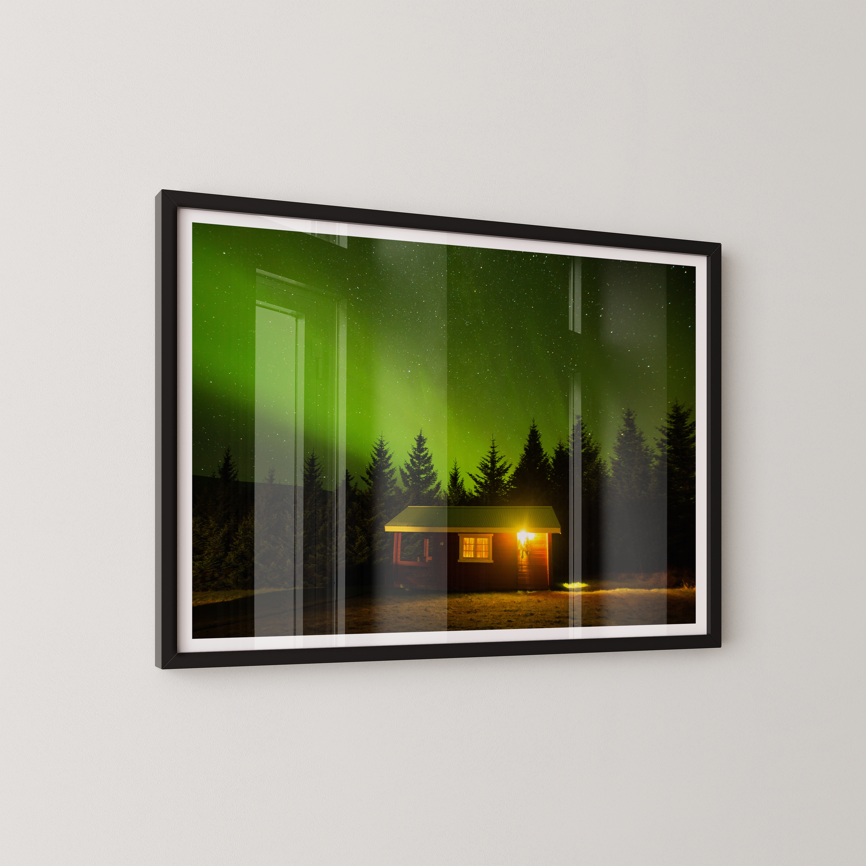 צילום אומנותי של בקתה מוארת בלב היער תחת מופע הזוהר הצפוני באיסלנד, מאת הצלם דניאל עובדיה.