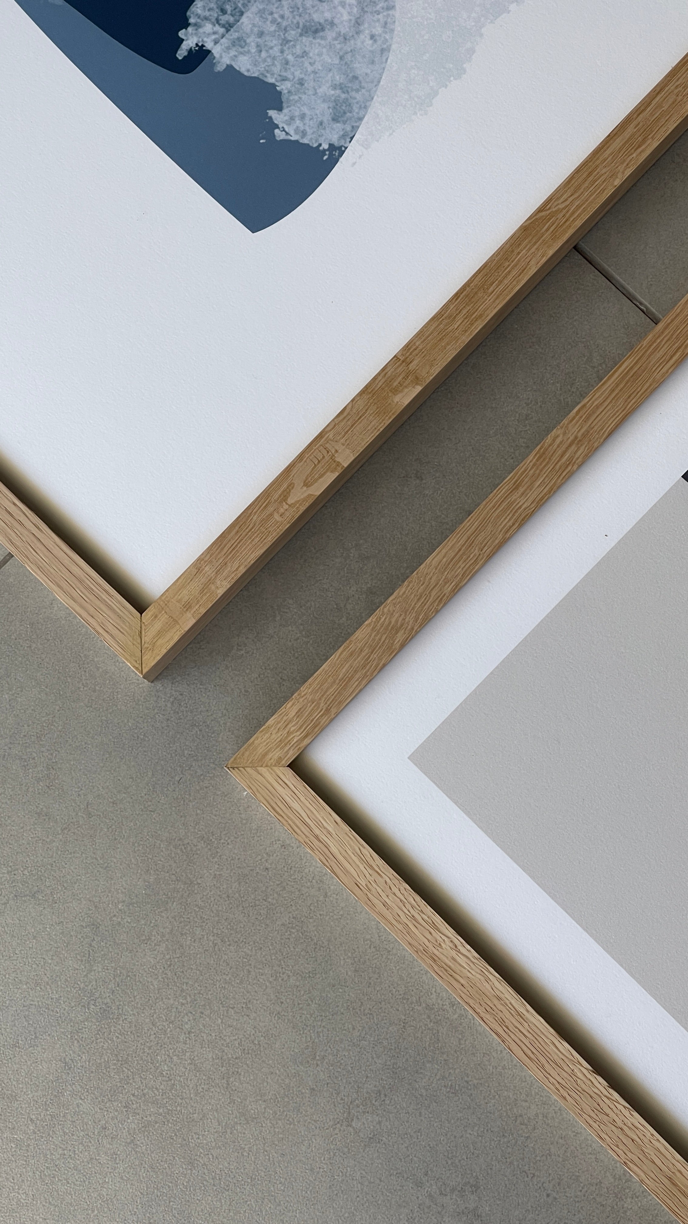 סט של שני פוסטרים ממוסגרים בסגנון אבסטרקטי, עם צורות אורגניות בגווני בז', כחול עמוק ואפרסק, המשדרים הרמוניה ורוגע.