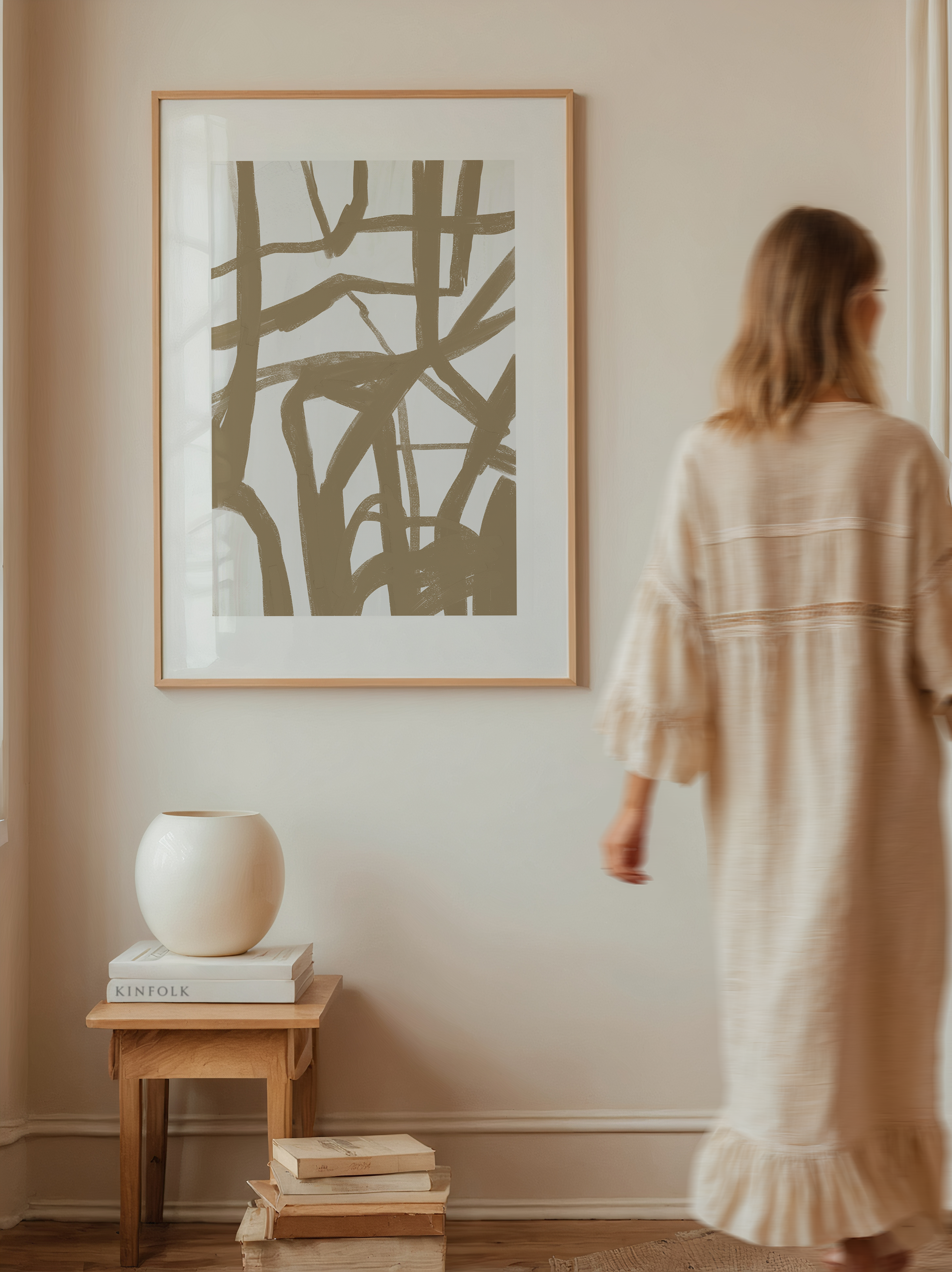 יצירת אמנות מופשטת בגוונים רכים עם קווים חופשיים, ממוסגרת ומוצגת על קיר בסגנון מודרני.