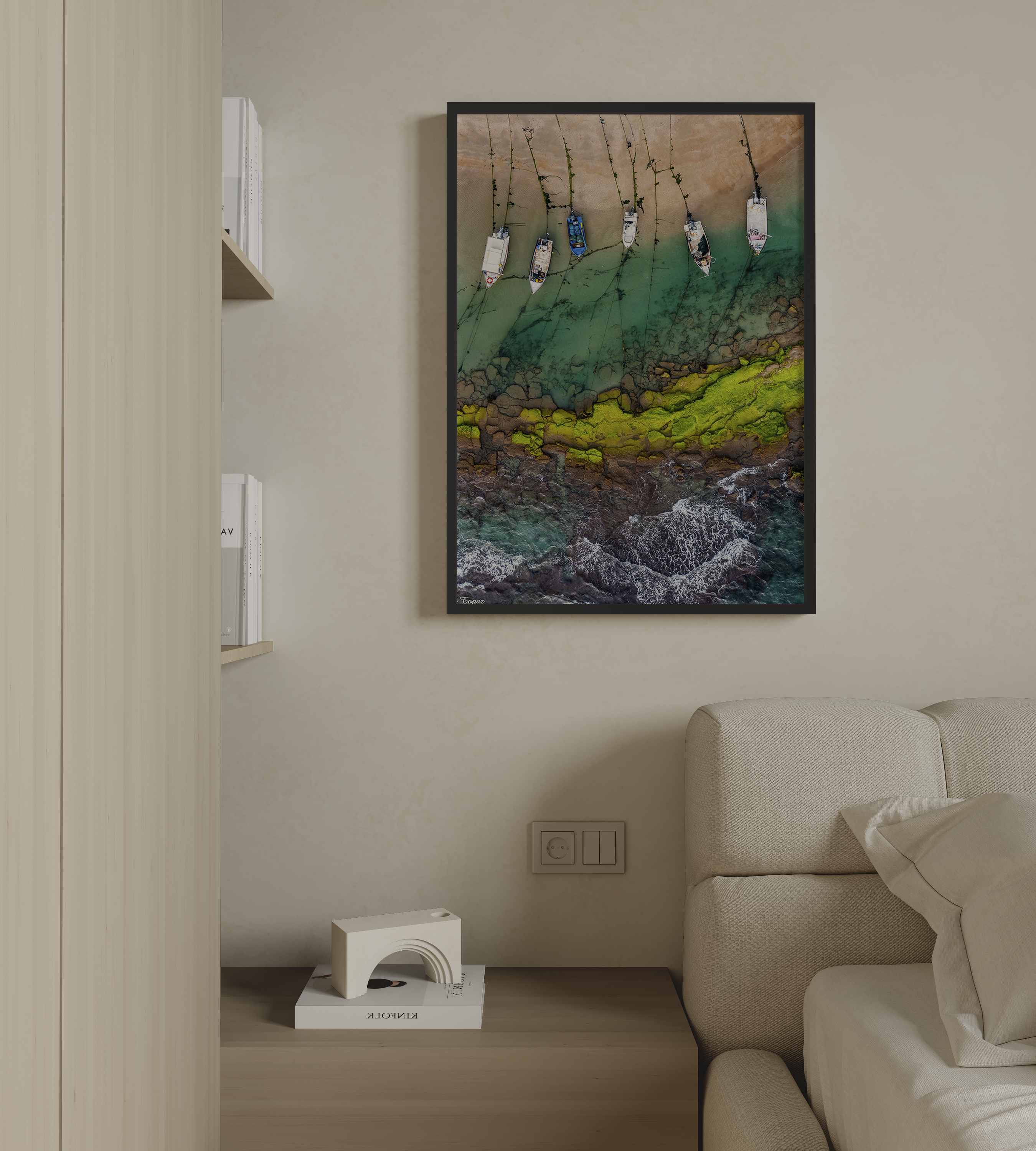 יצירה ממוסגרת של גלעד טופז בצילום אווירי של סירות דייגים עוגנות במים רדודים וטורקיז לאורך חוף סלעי בחדרה