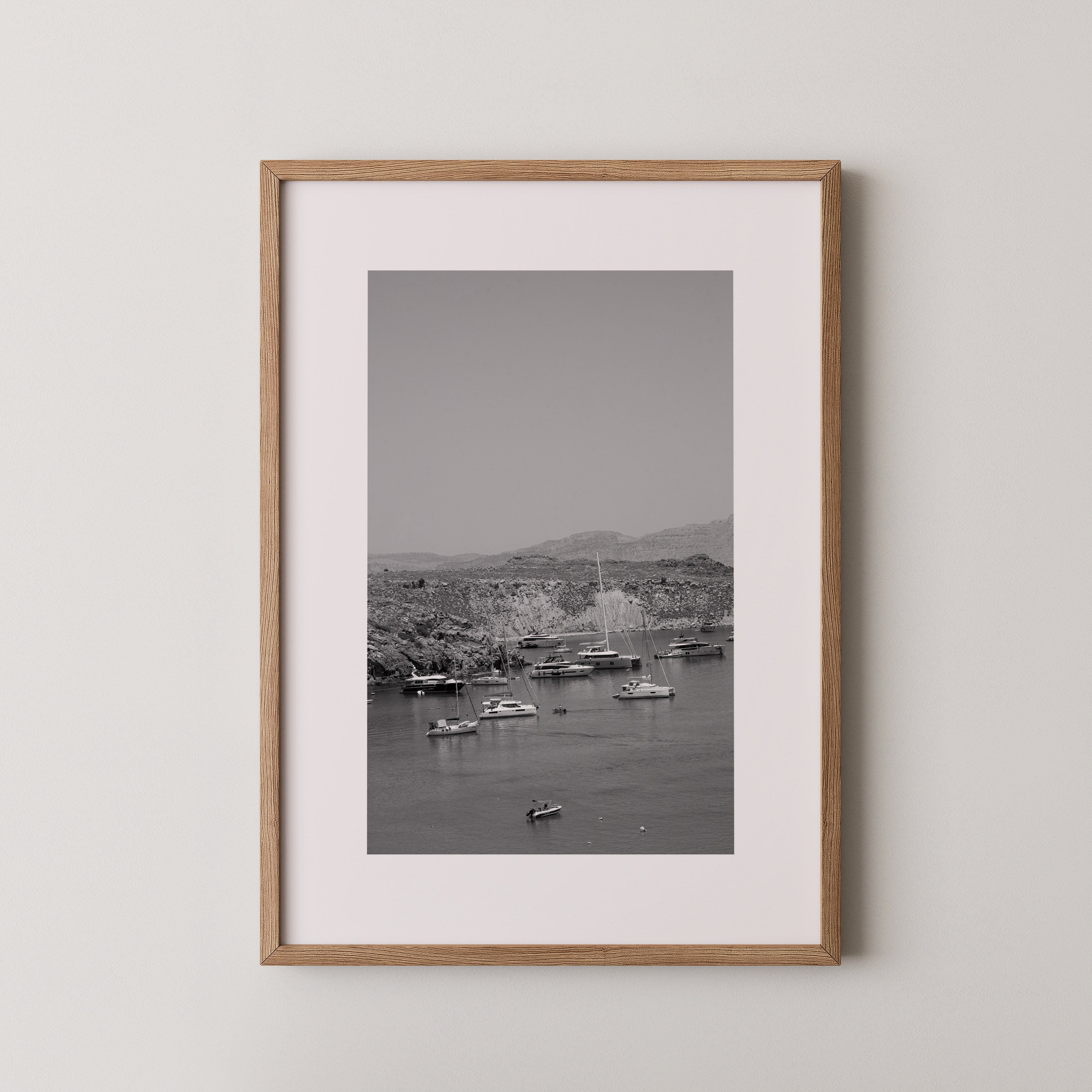 Quiet Harbor by Daniel Barlot – black and white Fine Art photograph of sailboats anchored in a peaceful Mediterranean harbor in Greece, framed in natural oak.
