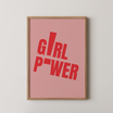 יצירת טיפוגרפיה מודרנית Girl Power בגווני ורוד פודרה ואדום במסגרת אלון טבעי, מתאימה לחדרי נערות, חדרי שינה, משרדים ופינות עבודה בעיצוב עכשווי.