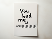 פוסטר טיפוגרפי עם הכיתוב "You had me at woof" בעיצוב שחור מינימליסטי, מונח על שטיח ליד בובת דובי.

