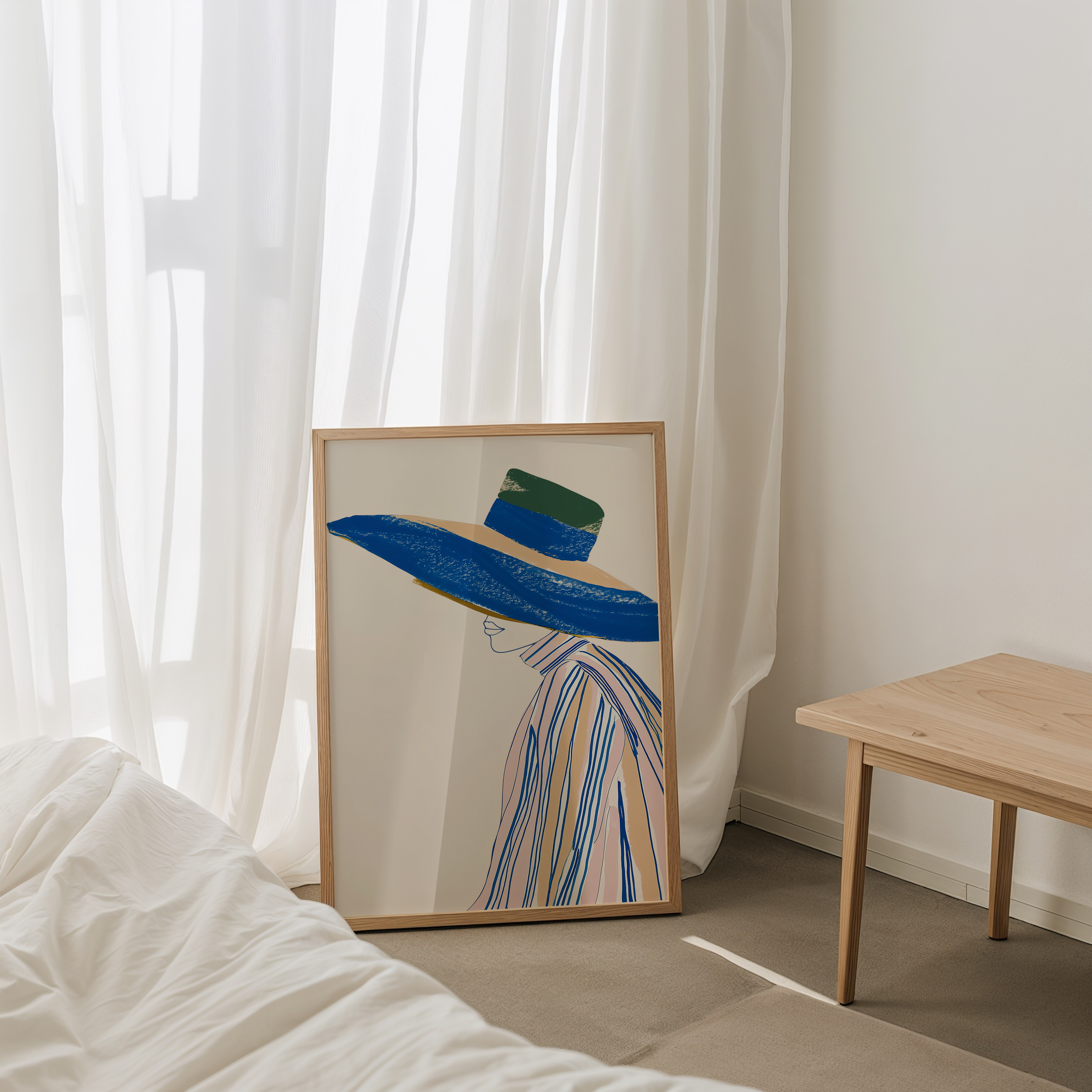יצירה ממוסגרת של דמות נשית בפרופיל עם כובע כחול רחב שוליים בגווני בז’, ירוק ואפרסק – Arlène מבית Trausi+Tosh