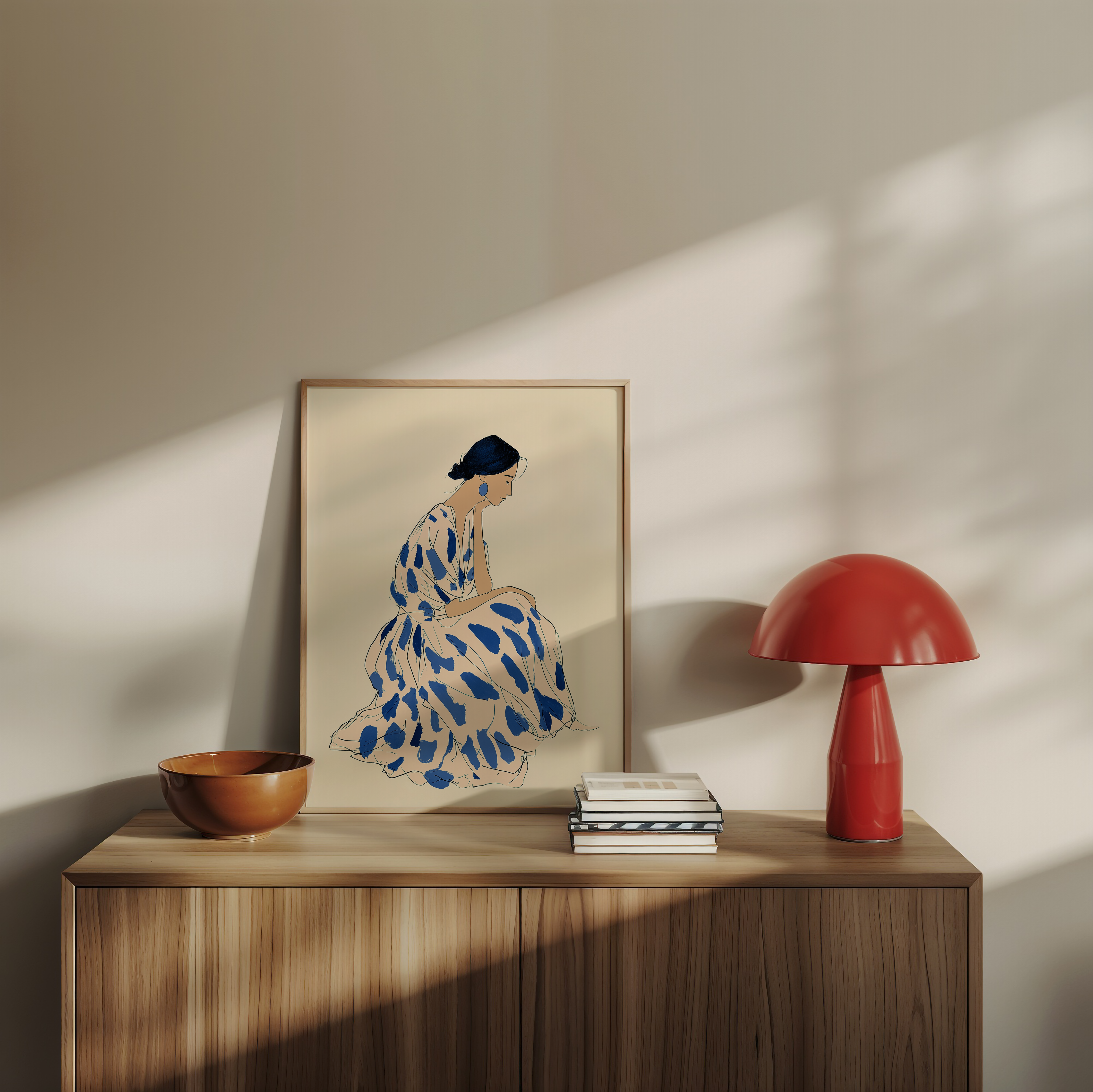 איור אמנותי של אישה יושבת בשמלה בהירה עם כתמים כחולים, בסגנון מינימליסטי, במסגרת שחורה/לבנה על קיר בהיר