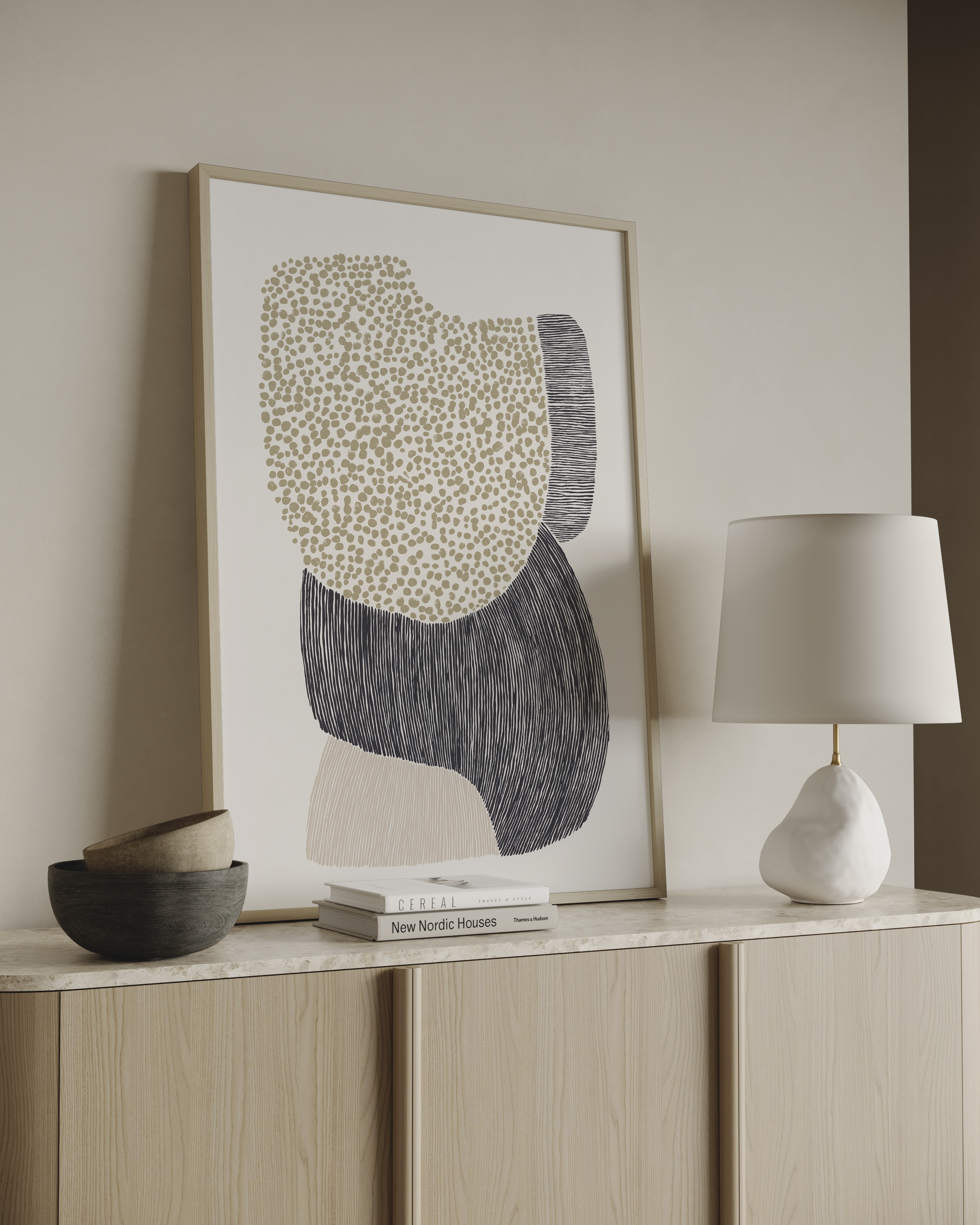 Halo Sand יצירת אמנות מינימליסטית בגווני חול, שחור ובז’ עם צורות אורגניות וטקסטורות טבעיות במסגרת בהירה על קיר ניטרלי