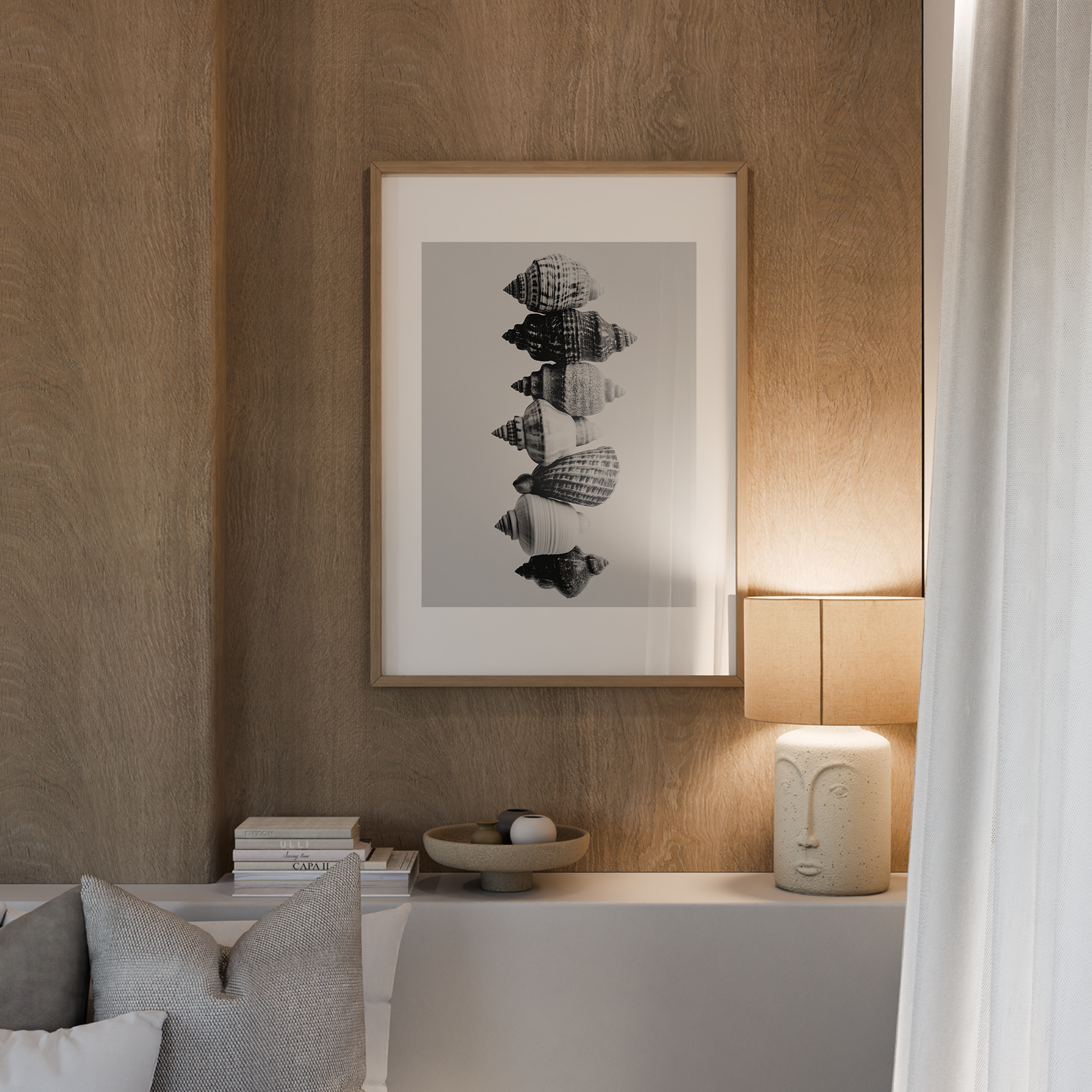 יצירת אמנות מינימליסטית של צדפים בשחור לבן בקומפוזיציה אנכית, מוצגת במסגרת עץ טבעי בחלל מודרני.